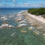 Tropical beach Balicasag Island Philippines with colorful reefs and snorkelers