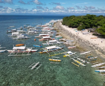 Tropical beach Balicasag Island Philippines with colorful reefs and snorkelers