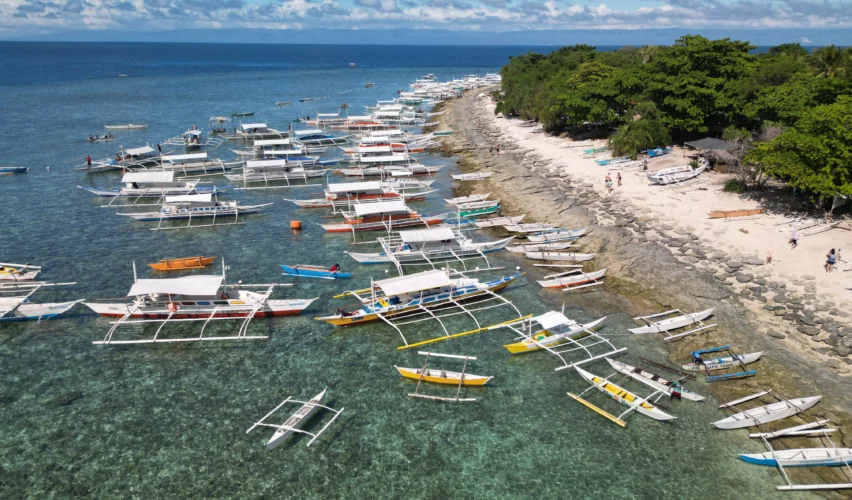 Tropical beach Balicasag Island Philippines with colorful reefs and snorkelers